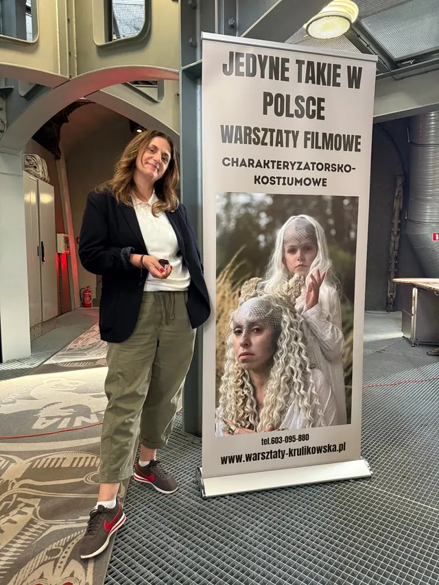 Kinga Krulikowska przy banerze warsztatów filmowych